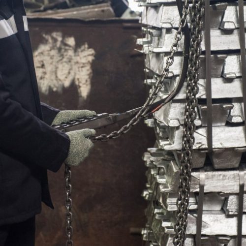 luminium factory stock metal worker in protective gloves in factory stock of aluminium sheet metal profiles